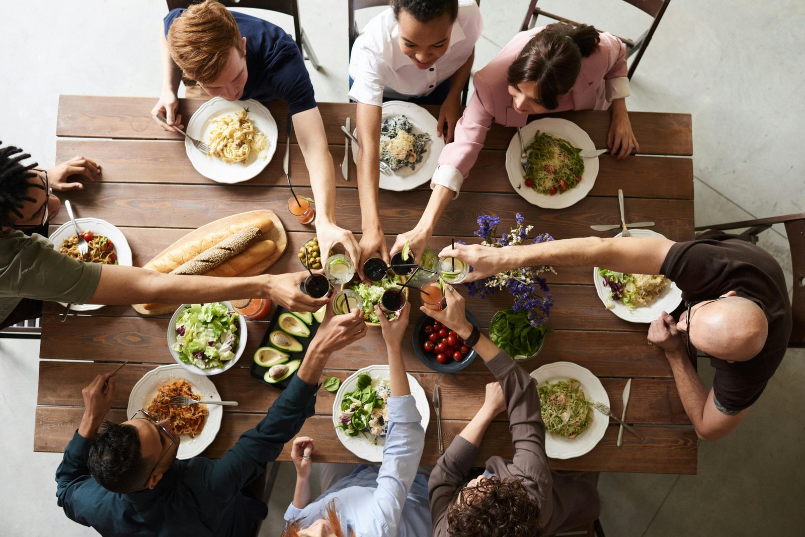 A stock photo of diverse group of colleagues smiling and eating lunch in a bright modern food court